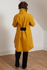 Woman wearing the Grace coat in mustard wool - back view