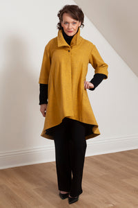 Woman wearing the Grace coat in mustard wool - front view