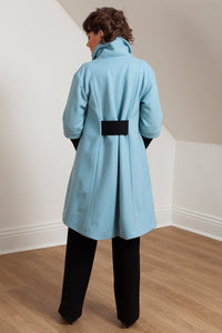 Woman wearing the Grace coat in icy blue wool - back view