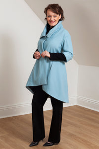 Woman wearing the Grace coat in icy blue wool - side view