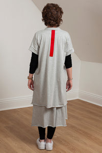 woman wearing a grey asymmetrical tunic with accent pocket - back view 