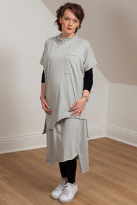 woman wearing a grey asymmetrical tunic with accent pocket - front/side view 